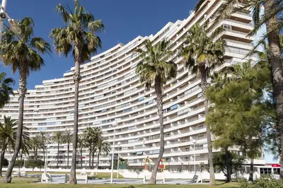 a large building with palm trees in front of it at Florazar 1, II-A 11-B in Cullera
