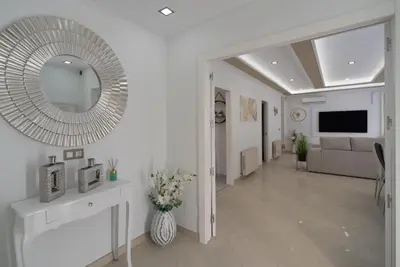 a white living room with a large mirror on the wall at DREAM HOUSE in Burriana