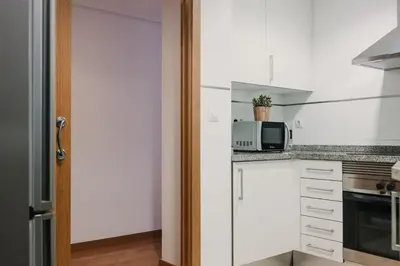 a kitchen with white cabinets and a microwave at Patacona Beach Apartment in Alboraya