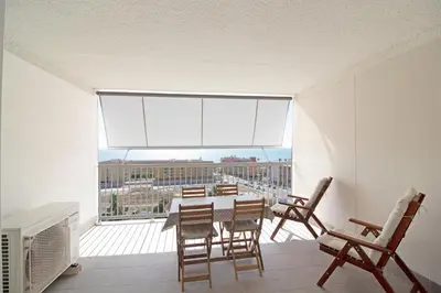 a dining room with a table and chairs and a large window at Global Vacacional, Apartamento con vistas al mar, Canet d'en Berenguer in Canet de Berenguer