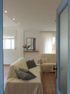a living room with a couch and a chair at ACOGEDOR ADOSADO entre mar y montaña in Cullera