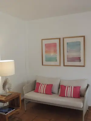 a living room with a couch with two pillows at ACOGEDOR ADOSADO entre mar y montaña in Cullera