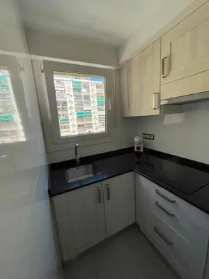 a kitchen with white cabinets and a sink and a window at Precioso apartamento de lujo en cullera in Cullera