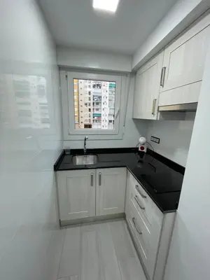 a white kitchen with a sink and a window at Precioso apartamento de lujo en cullera in Cullera