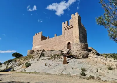 a large castle on a hill with a blue sky at Casa Rural Matilde in Caudiel