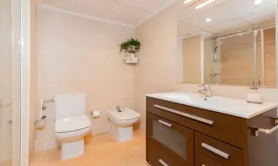 a bathroom with a toilet and a sink at Luxotica Gardens Valencia in Valencia