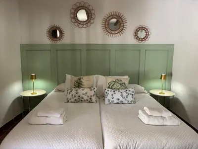a large white bed with pillows and mirrors on the wall at MASÍA de SAN JUAN CASA NÚMERO 1 en Castillo con piscina y Aire Acondicionado in Segorbe