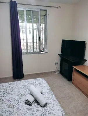 a bedroom with a bed and a flat screen tv at Habitación CID in Valencia