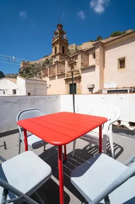 a red table and chairs on a roof at House Los Angeles in Chulilla