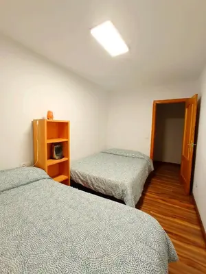 a room with two beds and a cabinet in it at Precioso piso in Catarroja