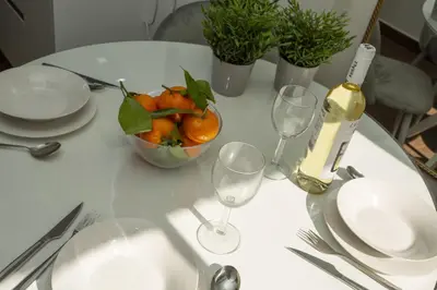 a table with a bowl of oranges and a bottle of wine at SingularStays Xativa III in Valencia