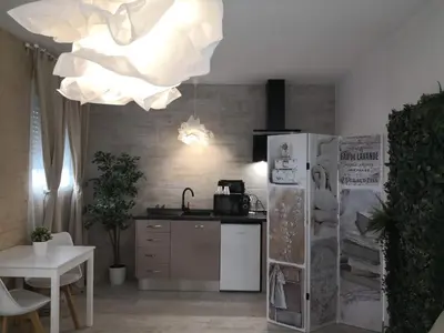 a kitchen with a refrigerator and a table and a chandelier at Cozy Rooms - BAÑERA HIDROMASAJE in Valencia