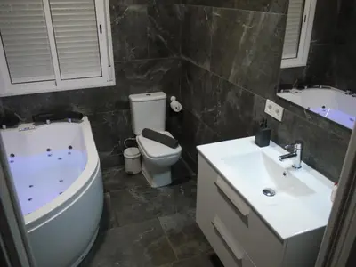 a bathroom with a toilet and a sink and a tub at Cozy Rooms - BAÑERA HIDROMASAJE in Valencia