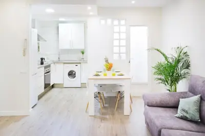 a kitchen and living room with a table and a couch at Cabanyal Luxury Malvarrosa Beach in Valencia