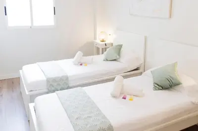 two beds in a room with white walls at Cabanyal Luxury Malvarrosa Beach in Valencia