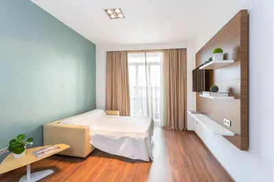 a bedroom with a bed and a table and a window at Center City Flats in Valencia