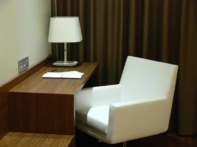 a desk with a white chair and a lamp on it at Center City Flats in Valencia