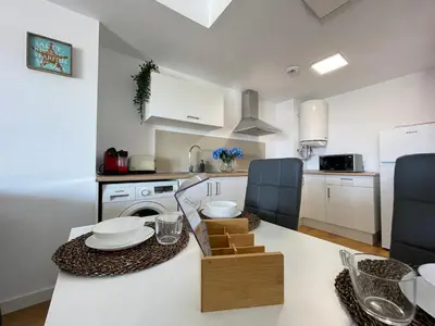 a kitchen with white cabinets and a table with dishes on it at Canet De Berenguer, Playa Apto con 2 habitaciones in Valencia