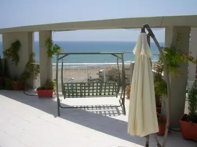 a closed umbrella on a balcony with a beach at MAGNIFICO ATICO-DUPLEX FRENTE AL MAR in El Puig