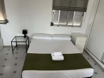 a bedroom with two beds and a table and a window at Attic Loft Gran Vía in Valencia