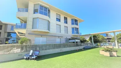 an apartment building with two chairs on a lawn at BEACH VALENCIA LUXURY - B40-21 - Apartament on Beach in Valencia