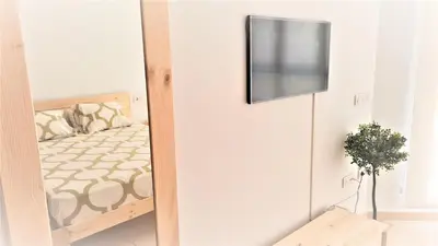 a room with a bed and a television on a wall at BEACH VALENCIA LUXURY - B40-21 - Apartament on Beach in Valencia