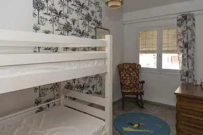 a bedroom with two bunk beds and a chair at Saint Germain, A-2-4 in Cullera