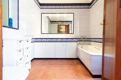 a bathroom with a tub and a sink and a mirror at Global Vacacional, Bonita casa rural en Quart de les Valls in Cuart de les Valls