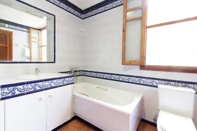 a bathroom with a tub and a sink and a mirror at Global Vacacional, Bonita casa rural en Quart de les Valls in Cuart de les Valls