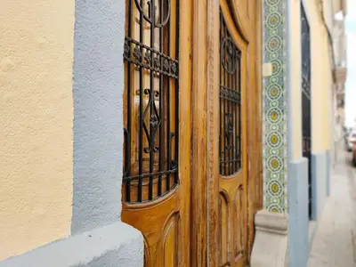a wooden door with a iron gate on a building at Global Vacacional, Bonita casa rural en Quart de les Valls in Cuart de les Valls