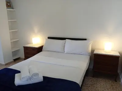 a bedroom with a bed with two lamps and towels at Town center Apartment El Perello Valencia in El Perelló
