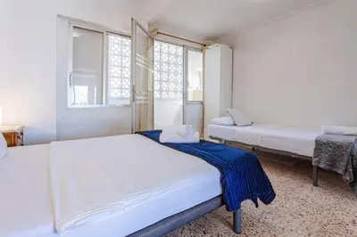 a bedroom with two beds and two windows at Town center Apartment El Perello Valencia in El Perelló