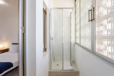a glass shower in a room with a bedroom at Town center Apartment El Perello Valencia in El Perelló
