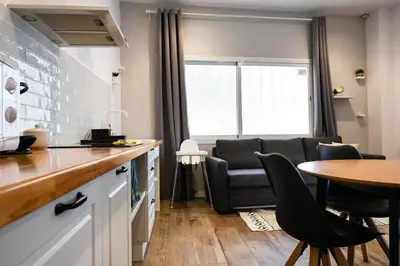 a kitchen and living room with a table and a couch at Playa Apartment in Valencia
