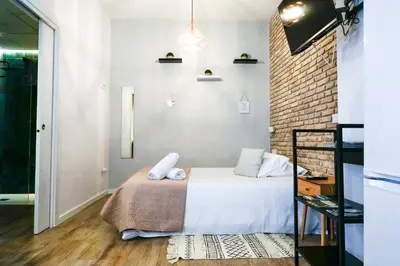 a bedroom with a bed and a brick wall at Playa Apartment in Valencia