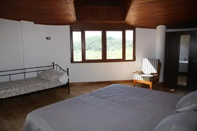 a bedroom with a bed and two windows at Casa Genes Chera in Chera