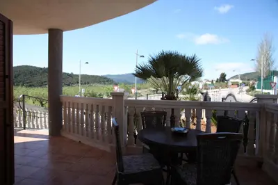 a patio with a table and chairs on a balcony at Casa Genes Chera in Chera
