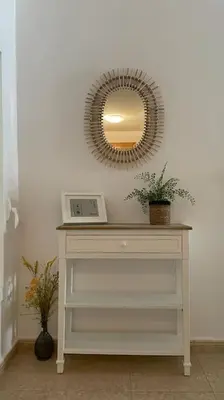 a white table with a mirror and a shelf with plants at Precioso apartamento con piscina en Moncofar in Moncófar