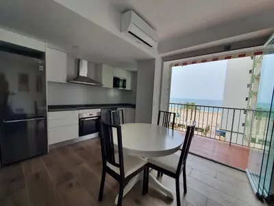 a kitchen with a table and chairs and a balcony at SingularStays Cullera IV in Cullera