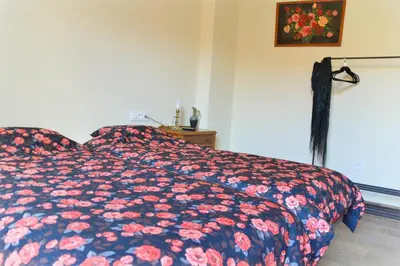 a bedroom with a bed with a floral comforter at Casa Bienvenida - Carcaixent in Carcagente