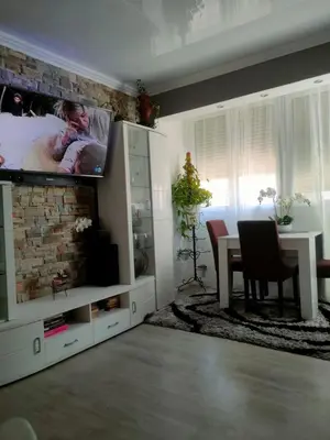 a living room with a tv on a brick wall at Vacansis Pintor Sorolla 2 in Cullera