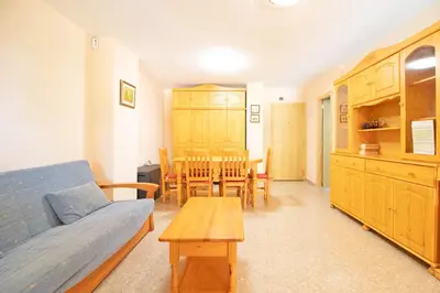 a living room with a couch and a table at Global Vacacional, Apartamento con piscina en Residencial Brezo in Canet de Berenguer
