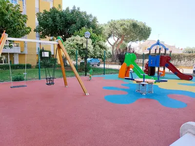 a playground with several slides and a swing set at Global Vacacional, Apartamento con piscina en Residencial Brezo in Canet de Berenguer