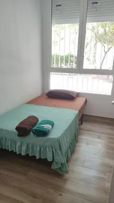 a bedroom with a bed in a room with two windows at Premier Apartments in Valencia