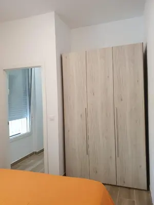 a bedroom with a wooden wardrobe and a mirror at Premier Apartments in Valencia
