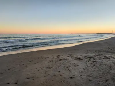 an empty beach at sunset with the ocean at Apartamento Casa Camacho in Burriana