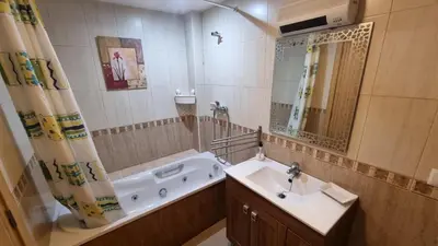 a bathroom with a tub and a sink and a mirror at Apartamento Casa Camacho in Burriana