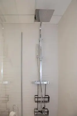 a shower in a bathroom next to a toilet at Jamaica Beach House in Puebla de Farnals