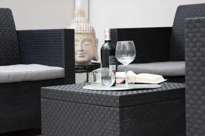 a table with a wine glass and a bottle of wine at Jamaica Beach House in Puebla de Farnals