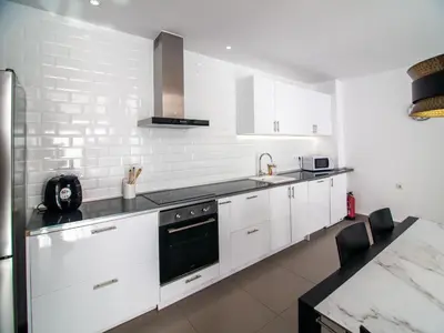 a kitchen with white cabinets and a black stove top oven at MD Loft Valterna in Paterna